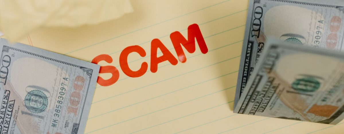 money on table with "scam" written on table