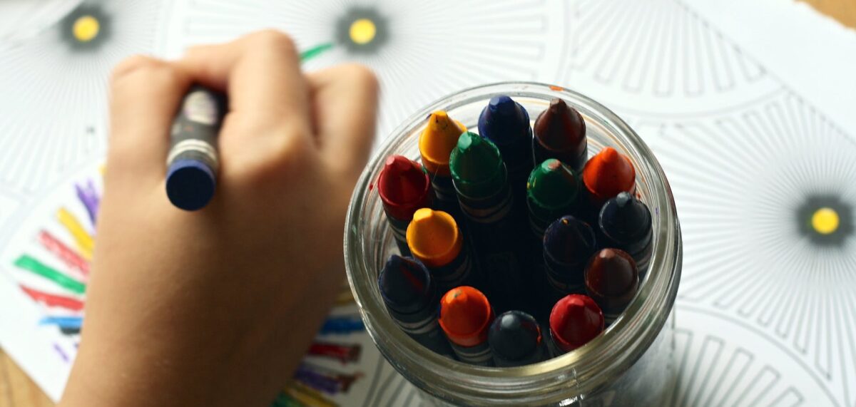 child in daycare coloring art with crayons