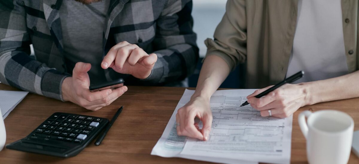 two people doing paperwork and computing taxes